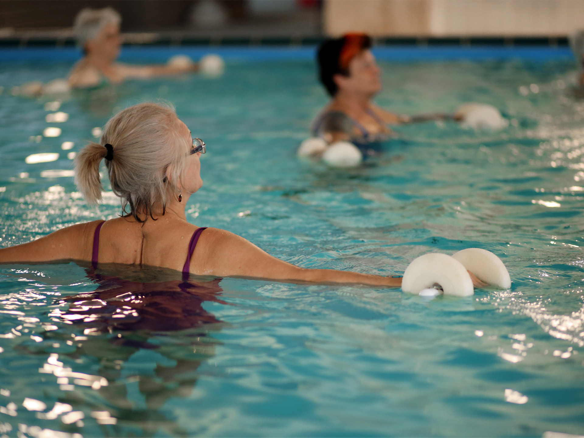 Patientin macht Wassergymnastik im Pool